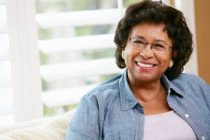 African american woman wearing glasses and sitting in front of window