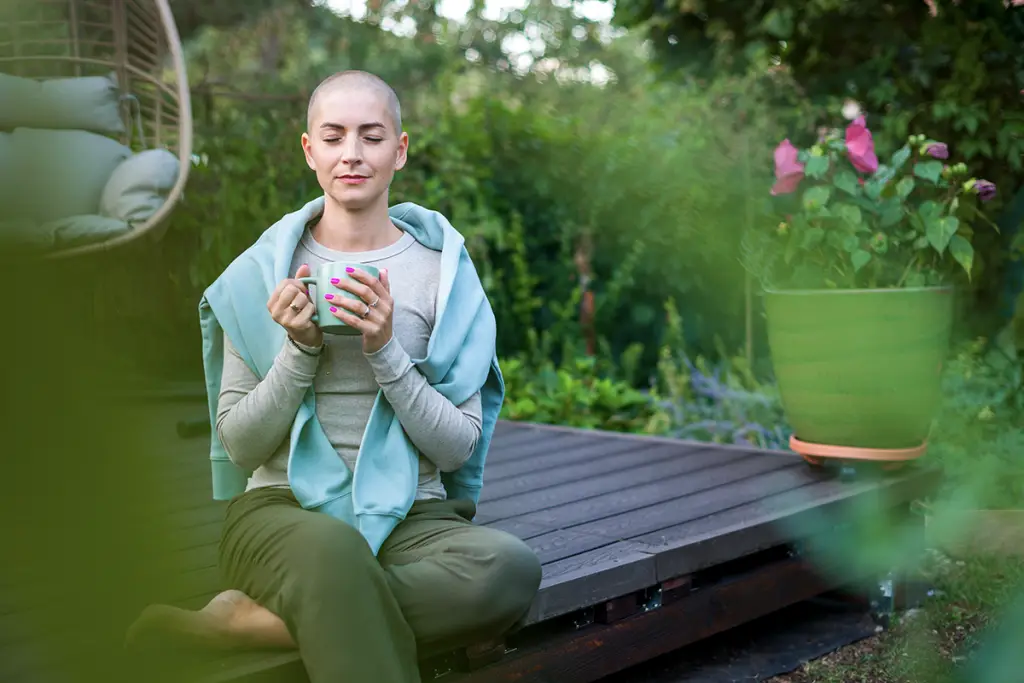 Woman with cancer meditating outside
