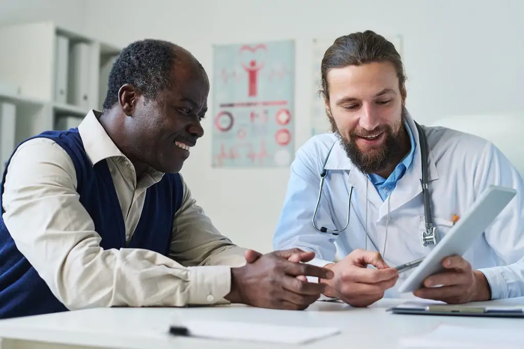 Man looking at test results with doctor
