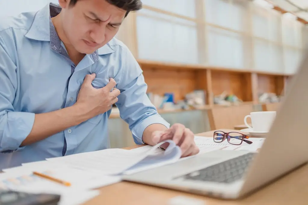 Man holding chest at work