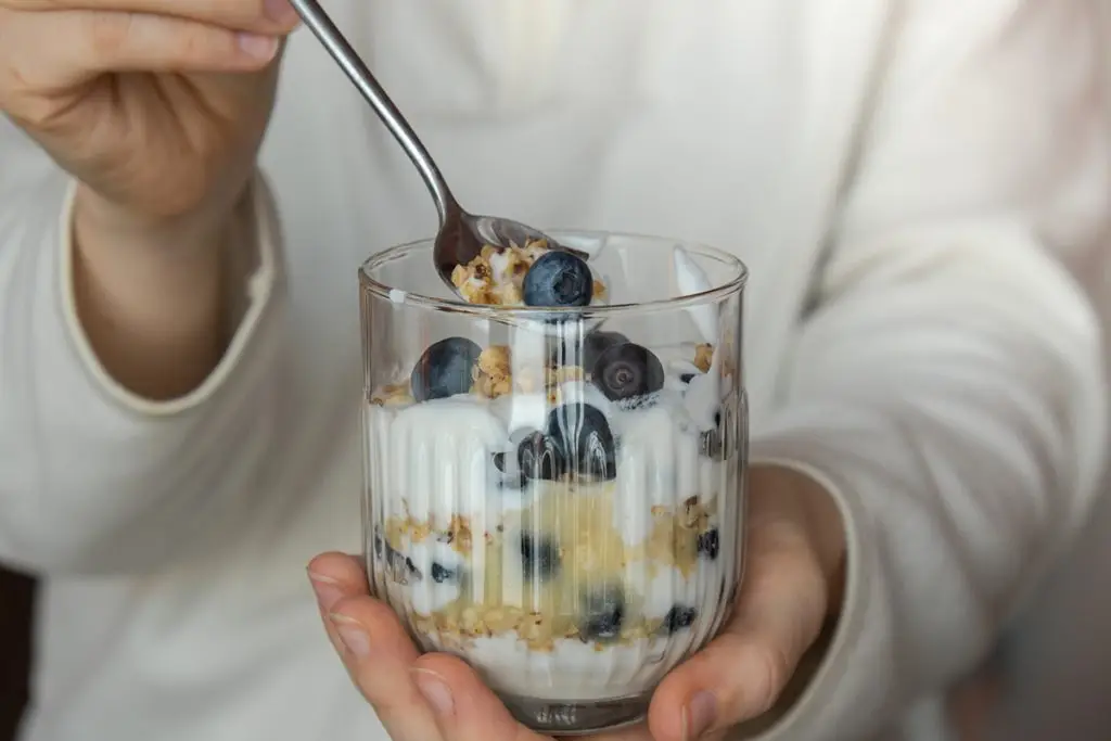 Woman eating breakfast of yogurt