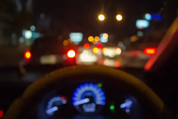 Blurry image behind the wheel of a car
