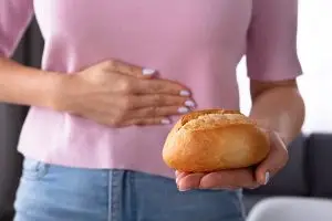 Woman with bread also holding her stomach
