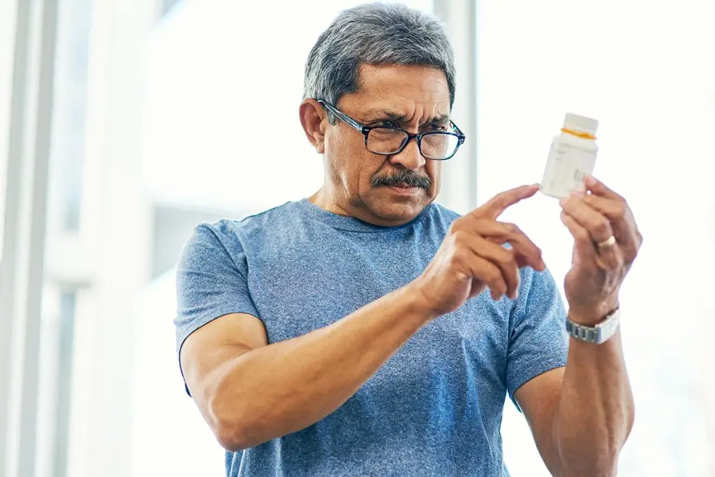 Man looking at medicine bottle