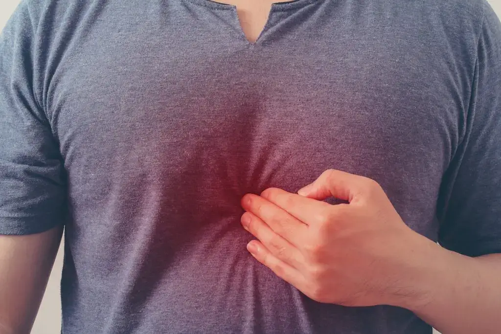 Man putting hand over heart when feeling chest pain