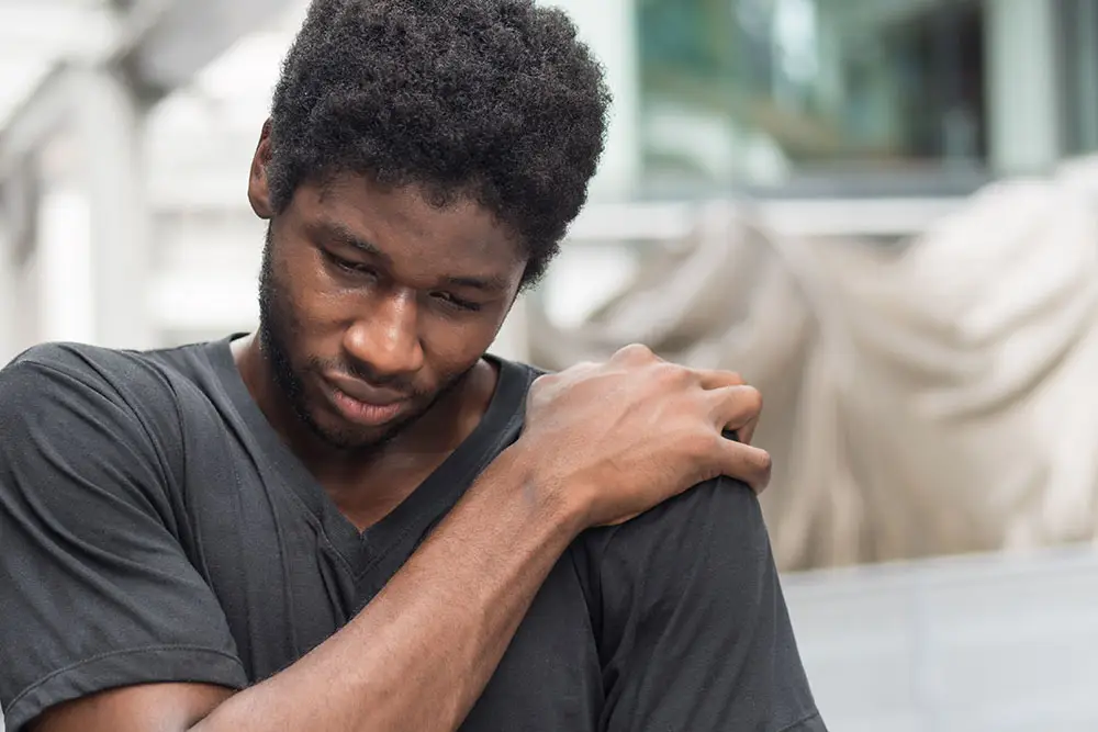Young man gripping shoulder in pain