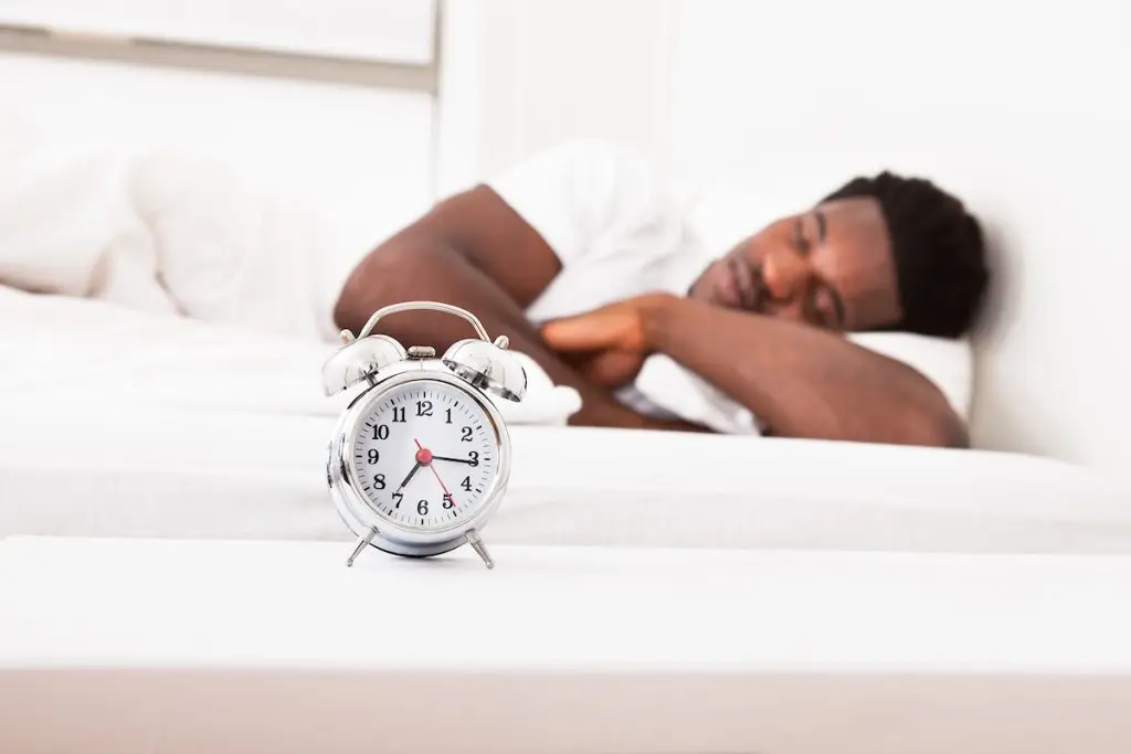 Man sleeping near alarm clock
