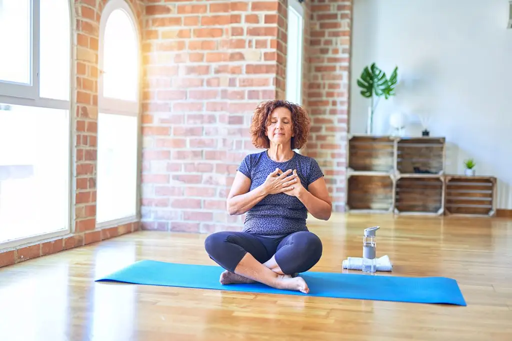 Woman meditating with hand on her heart