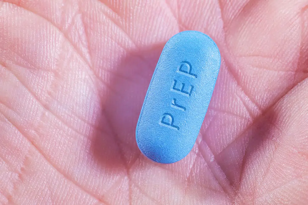 Person holding PrEP pill in the palm of their hand