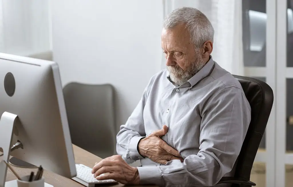 Senior man holding his stomach in pain