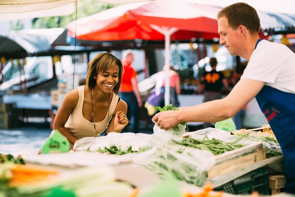 Young woman shopping for produce at farmers market