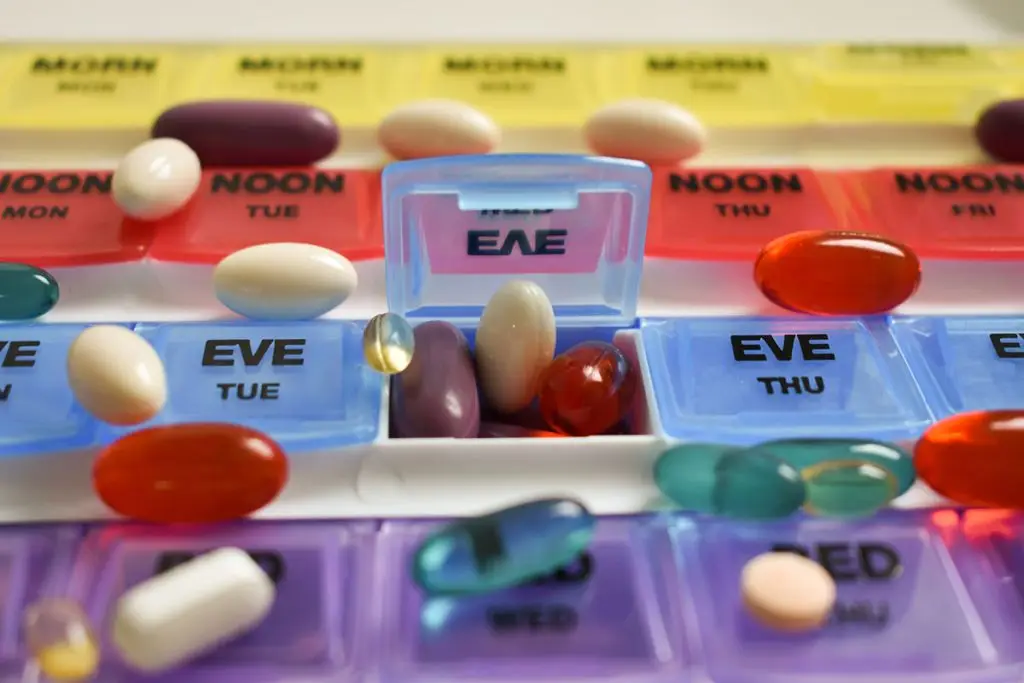 Different pills bursting out of a pill organizer
