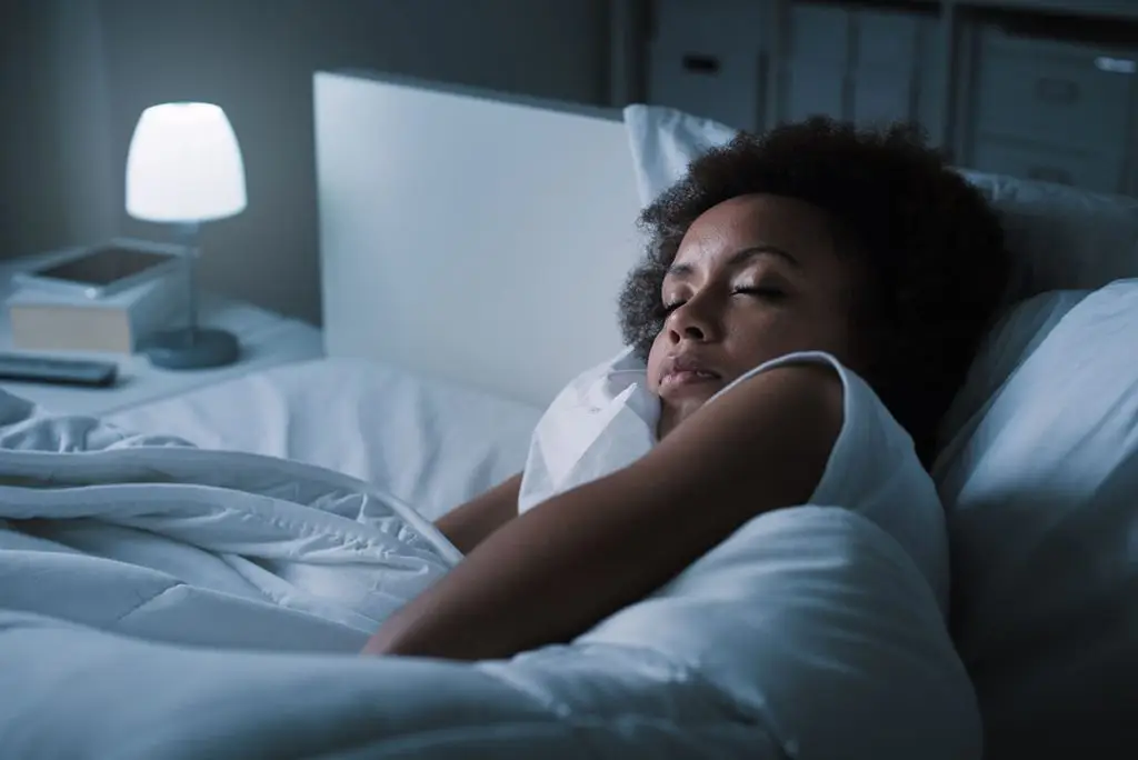Woman sleeping fitfully in bed at night