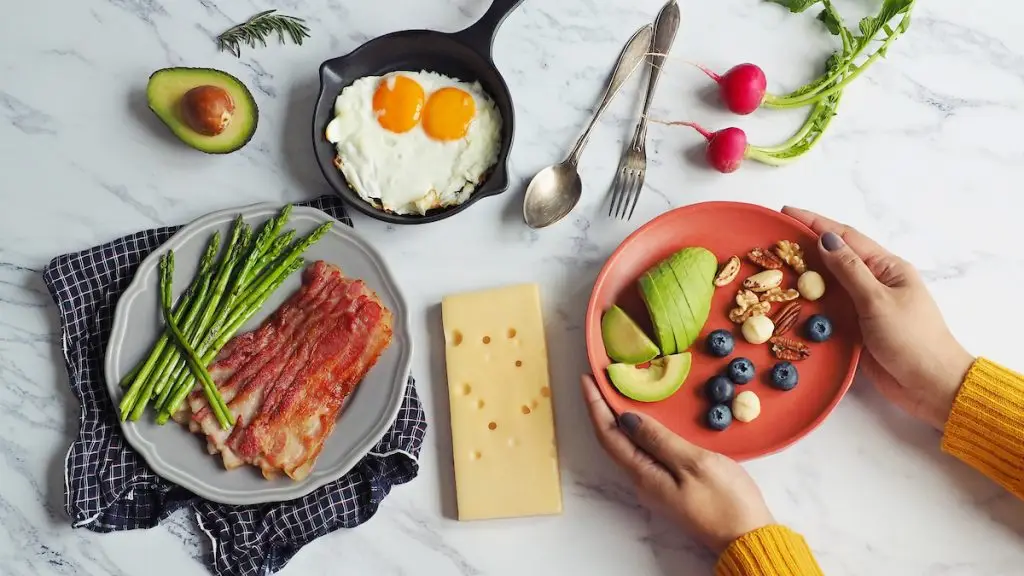 Woman putting down plate of keto-friendly foods on kitchen counter