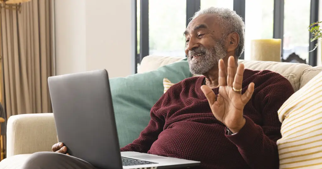 Man waving at Laptop