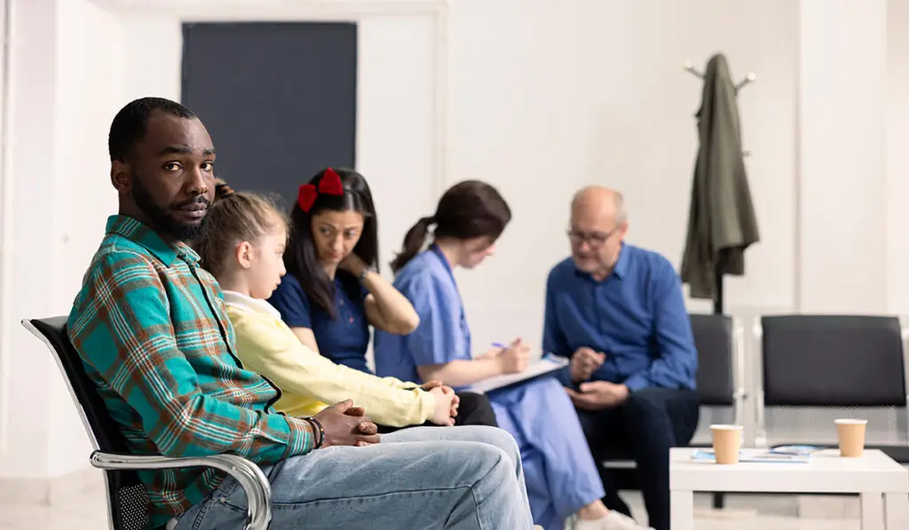 Man in waiting room with other people
