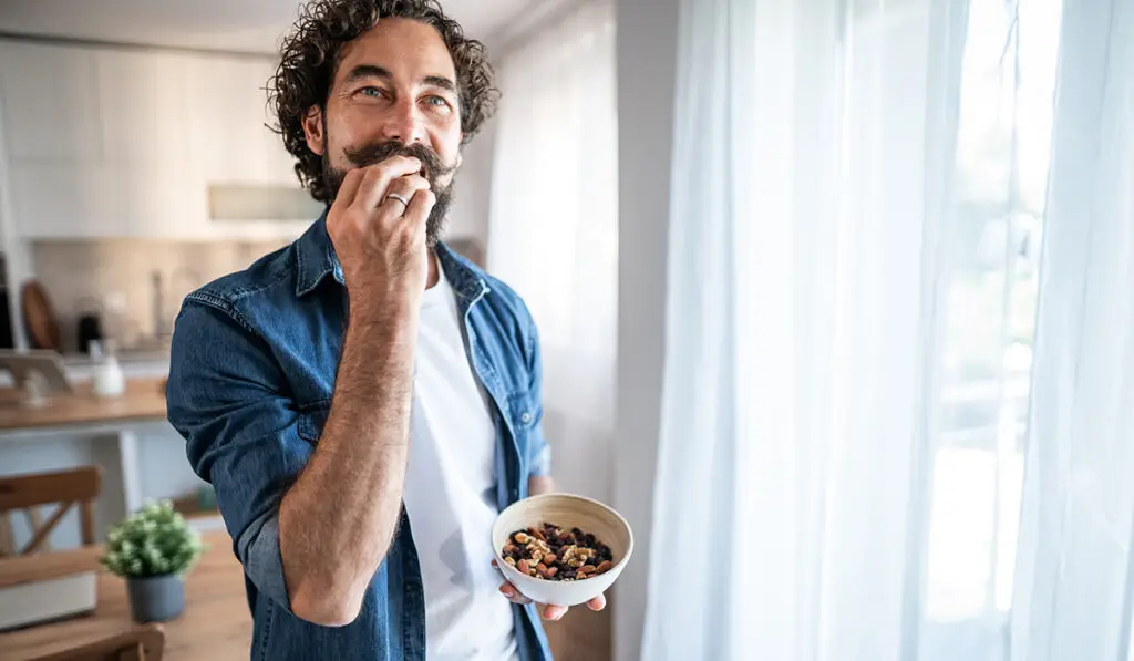 Man eating a bowl of trail mix